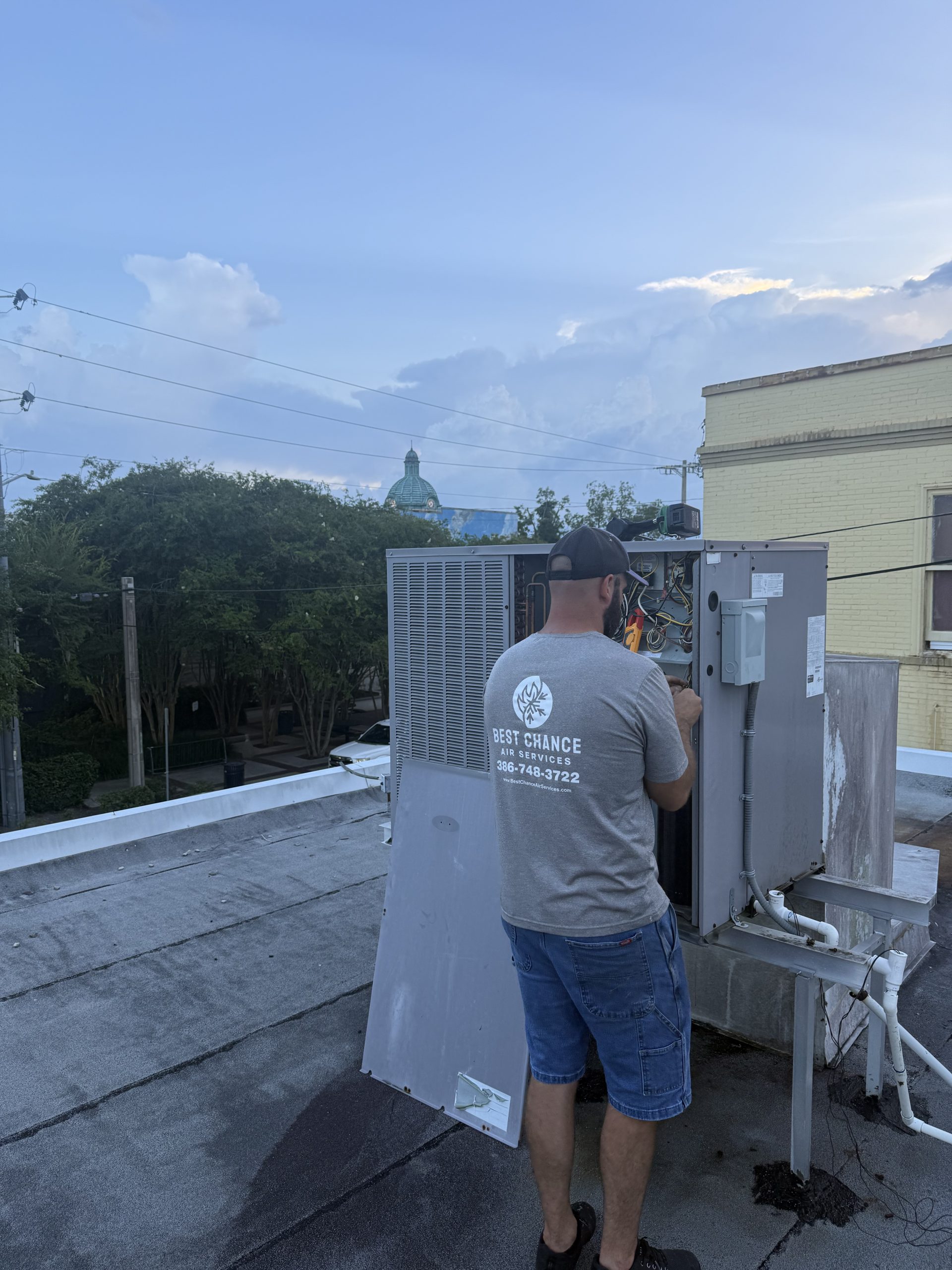 Best Chance Air Services technician repairing commercial rooftop unit