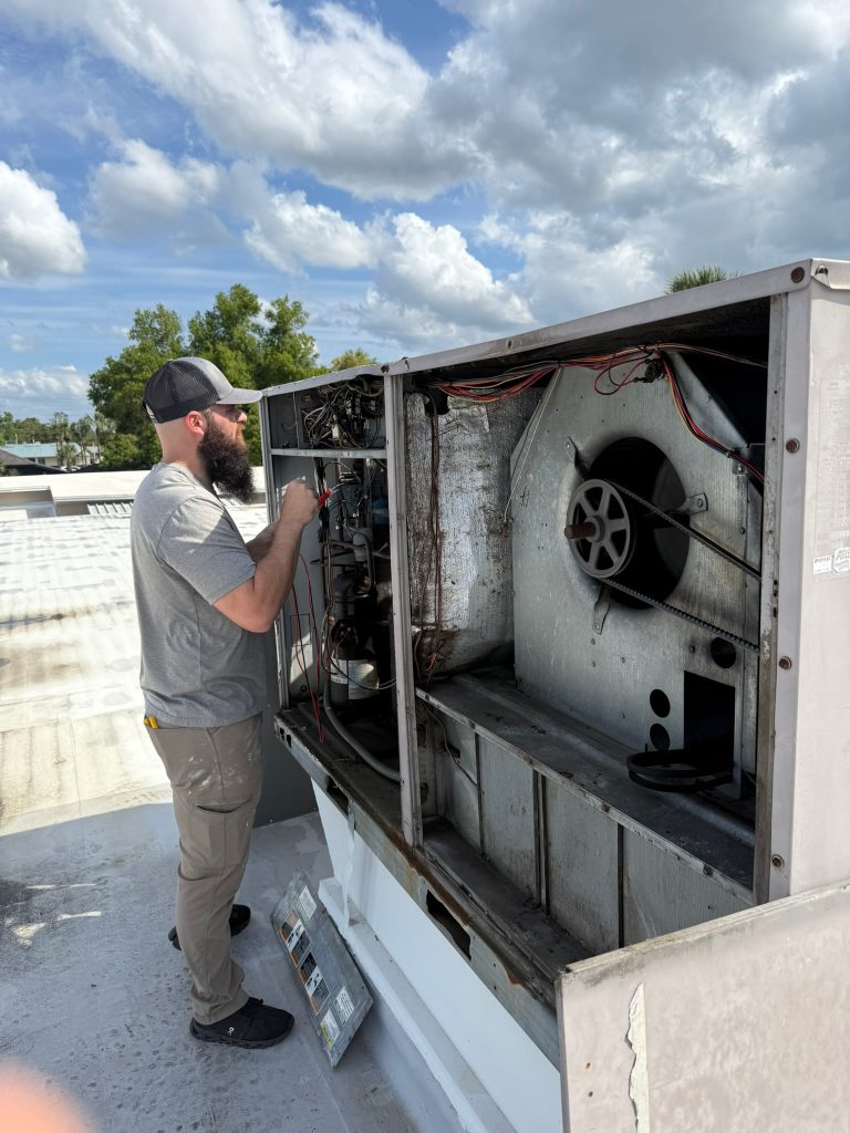 Best Chance Air Services technician diagnosing rooftop AC unit in Central Florida